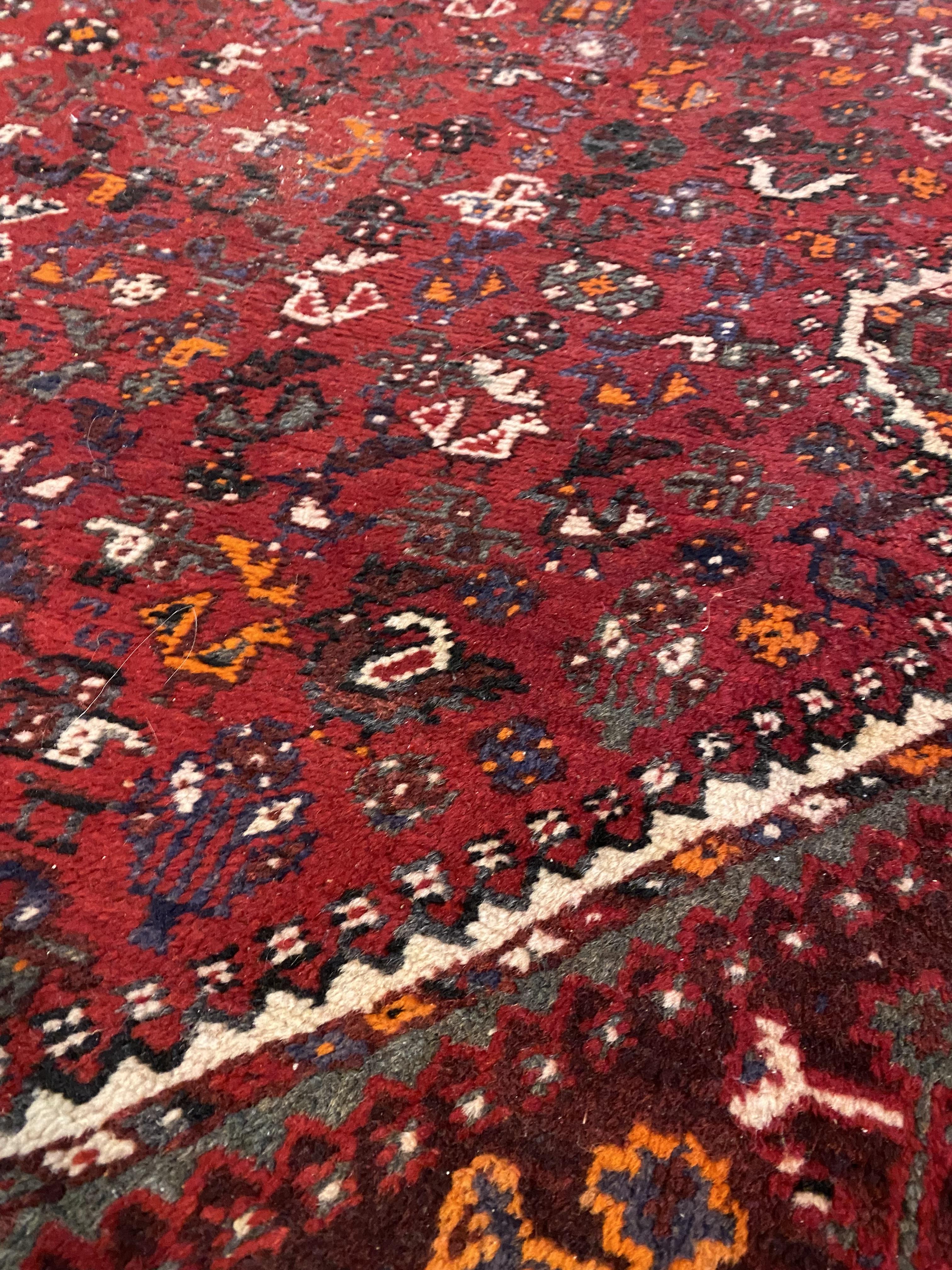 A Shiraz hand knotted carpet, the red field with pole medallion and intricately decorated with - Image 2 of 3