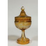A 19th century Bohemian etched amber glass jar and cover, the cover with faceted knop and etched