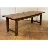 A large French vernacular fruitwood dining table, early 19th century, the scrub top raised on square