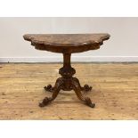A Victorian figured walnut card table, the top, of serpentine outline, folding and revolving to
