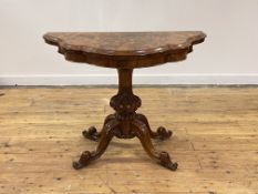 A Victorian figured walnut card table, the top, of serpentine outline, folding and revolving to