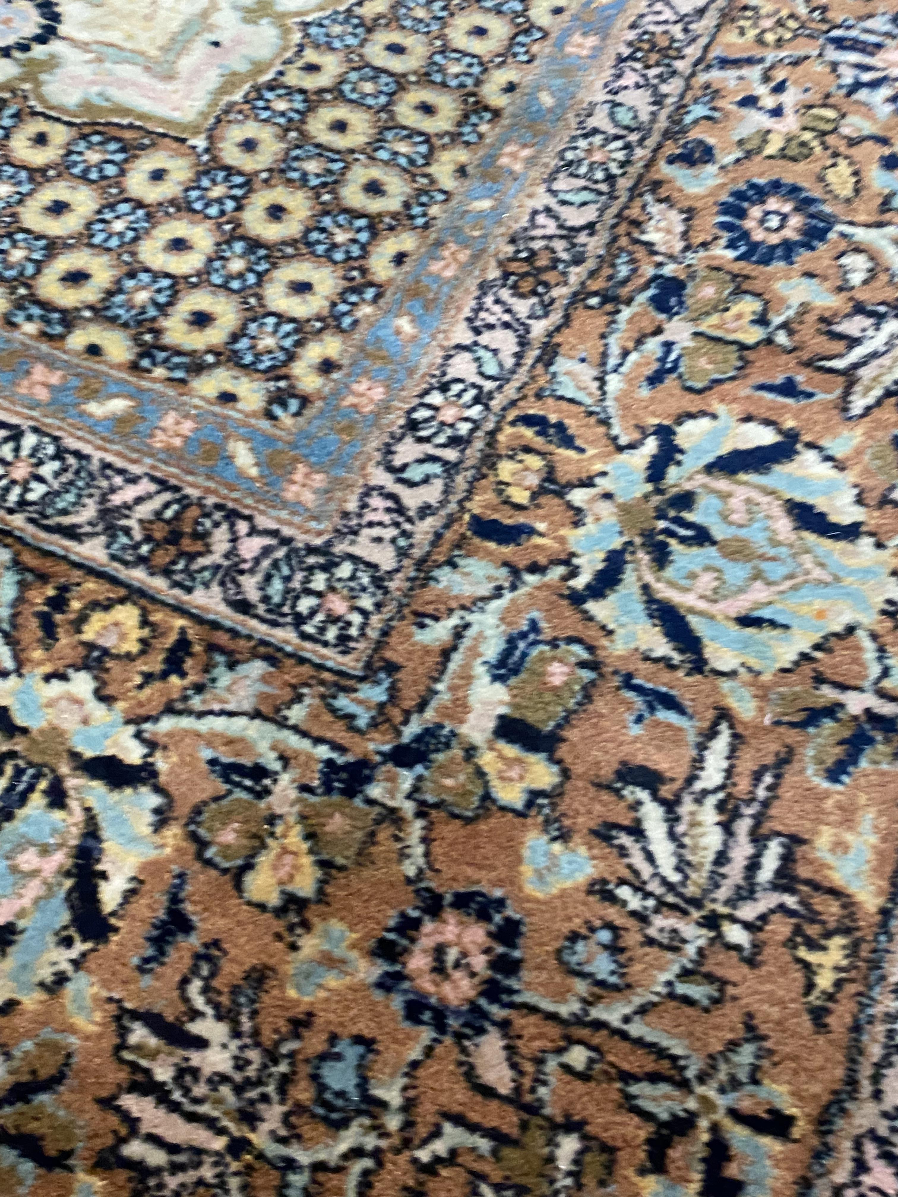 A Persian Tabriz carpet, hand knotted, the ivory field decorated with repeating flower heads and - Image 2 of 3