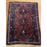 A Persian Shiraz rug, hand knotted, the red field with pole medallion flower heads and birds, within