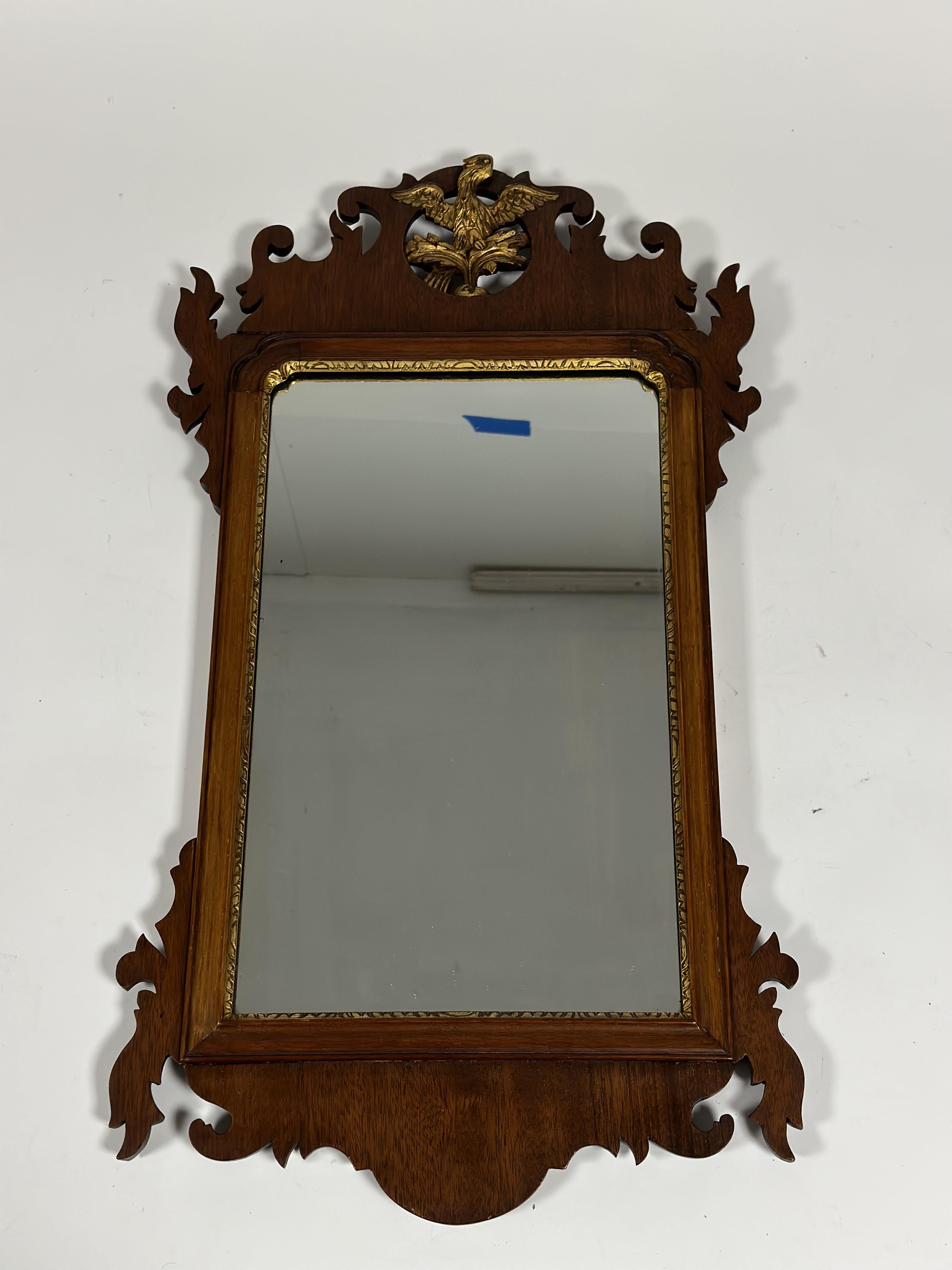 A George III style parcel-gilt walnut fretwork mirror, with ho-ho bird crest. Overall 71cm by 39cm