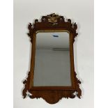 A George III style parcel-gilt walnut fretwork mirror, with ho-ho bird crest. Overall 71cm by 39cm