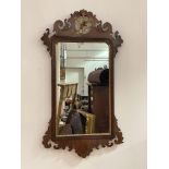 A George III parcel-gilt walnut fretwork mirror, the (distressed) plate within a shaped gilt slip,