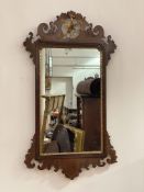 A George III parcel-gilt walnut fretwork mirror, the (distressed) plate within a shaped gilt slip,