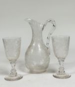 An etched glass wine ewer, of baluster shape with moulded ropetwist handle, densely etched with vine