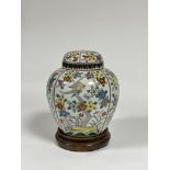 A Chinese famille rose porcelain jar and cover, decorated with panels of birds perching amidst