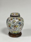 A Chinese famille rose porcelain jar and cover, decorated with panels of birds perching amidst