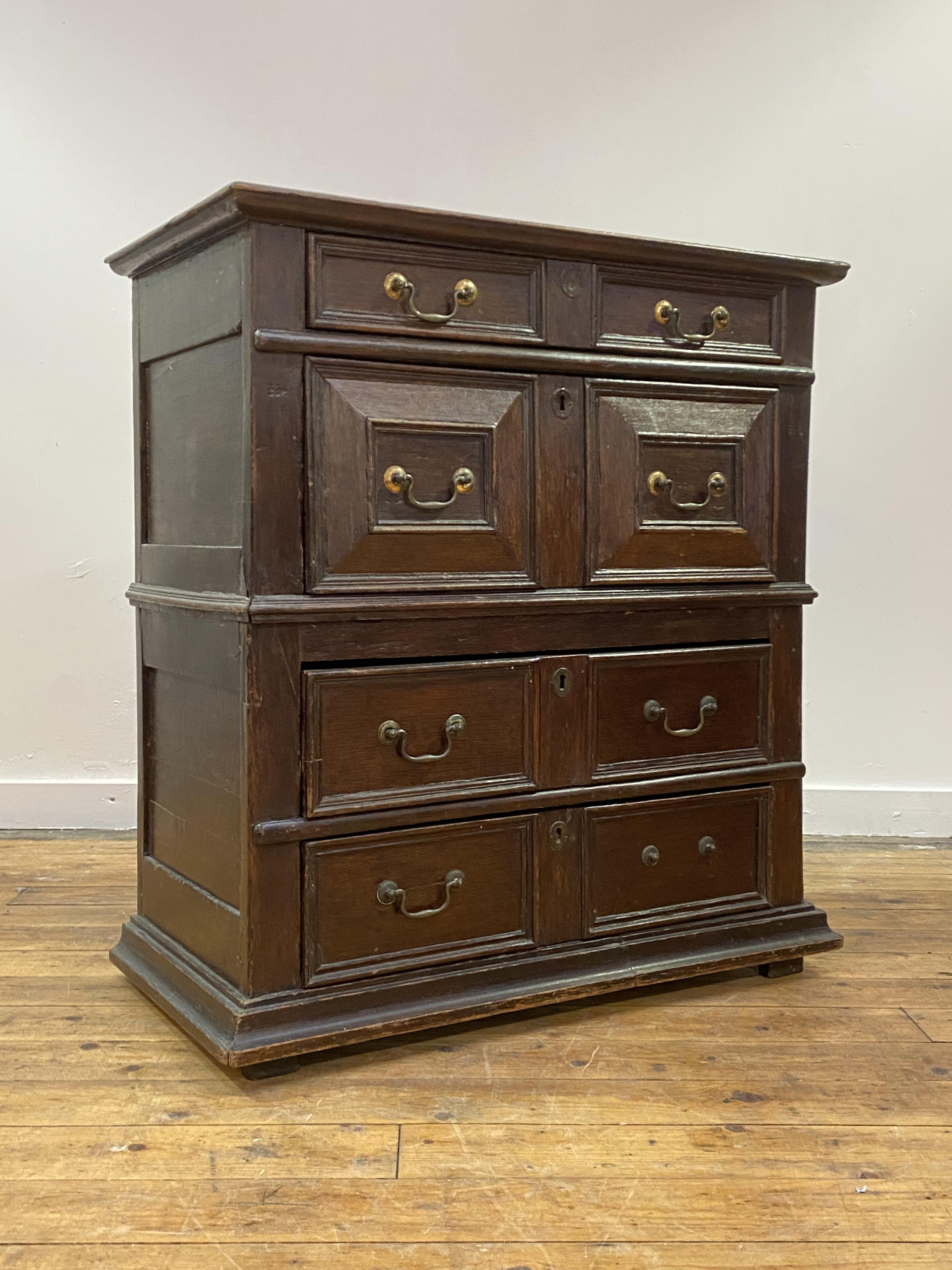 An oak chest of drawers, early 17th century and later, the top with moulded edge over four panel