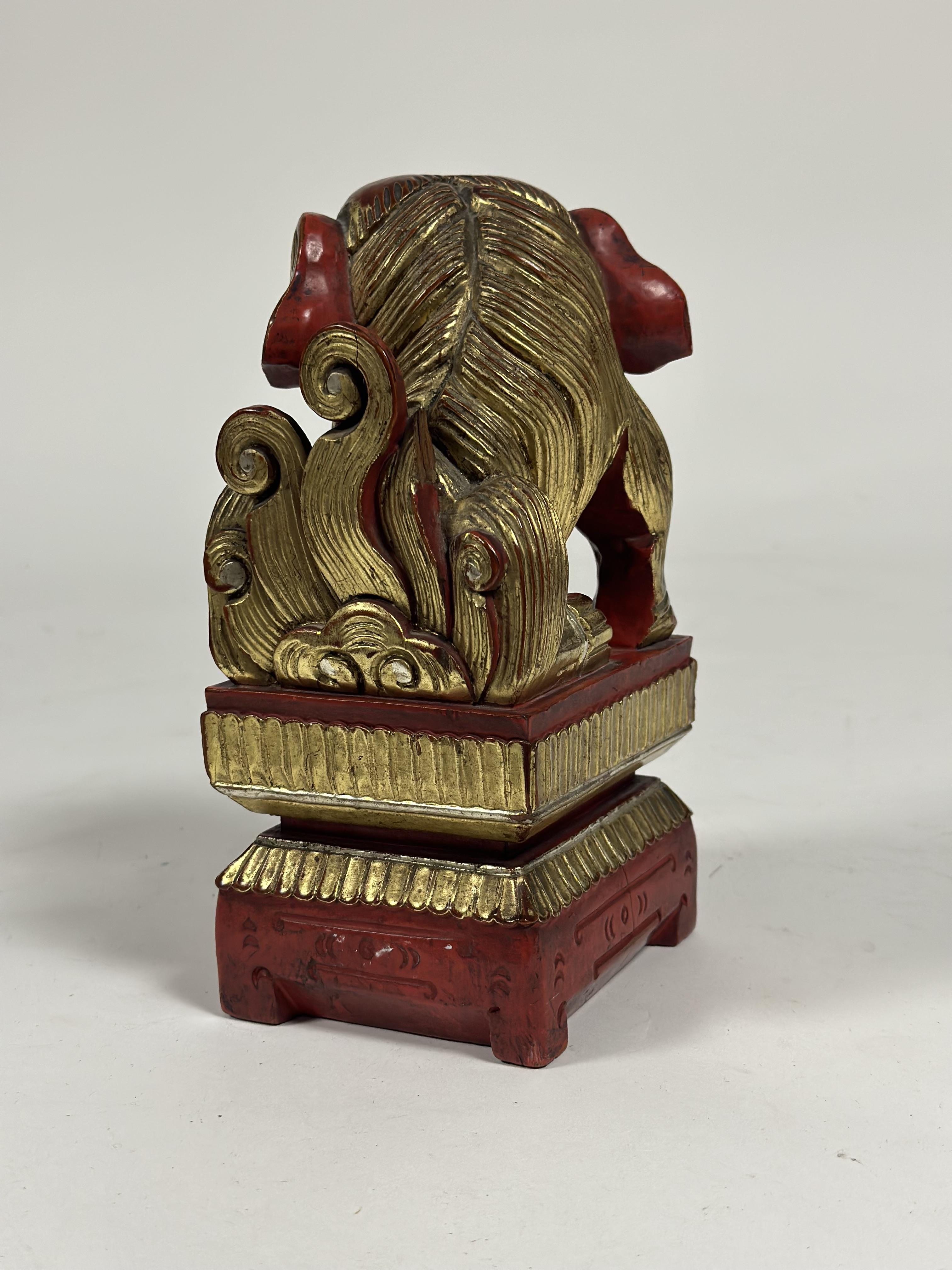 A Chinese red lacquer model of a Buddhistic lion, modelled with fabric ball on an integral stand, - Image 2 of 2