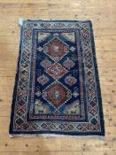 An Antique Turkish rug, the blue field with pole medallion, framed within an ivory border having