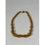 A single graduated strand of "butterscotch" amber beads with small amber spacers, on an amber-