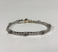 An Italian sapphire-set 18ct white gold bracelet by UnoAErre, of engraved fancy links, spaced by