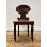 A William IV mahogany hall chair, the shell back of cartouche form carved with 'C' scrolls, over