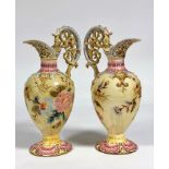 Zsolnay Pecs: a pair of floral-decorated ewers, each moulded and painted with floral sprays and c-