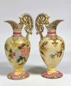 Zsolnay Pecs: a pair of floral-decorated ewers, each moulded and painted with floral sprays and c-