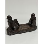 A Chinese carved wooden group of two seated figures playing "Go", unsigned. Height 23cm, length