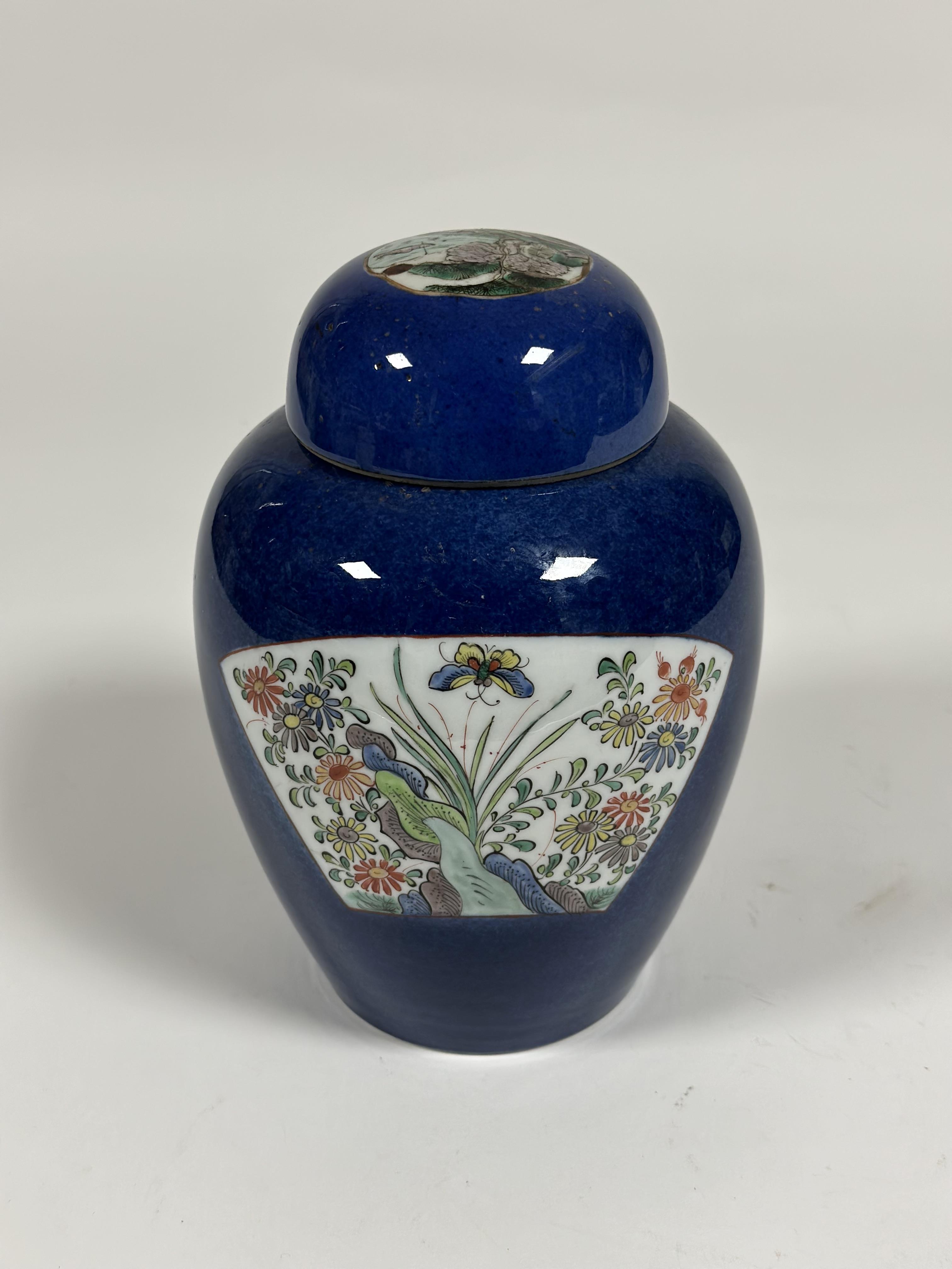 A Chinese porcelain jar and cover, painted with a pair of famille rose fan-shaped cartouches with