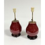 A pair of Chinese monochrome glazed sang de boeuf porcelain vases, mounted as table lamps, of