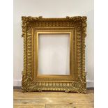 An elaborate 19th century giltwood and gesso picture frame, rectangular, the deep concave moulded