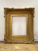 An elaborate 19th century giltwood and gesso picture frame, rectangular, the deep concave moulded