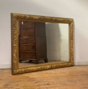 A large late 19th century giltwood and composition wall mirror, the frame with moulded flowerhead