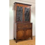 An early 19th century mahogany secretaire bookcase, the dentil cornice over a well figured frieze,