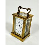 A Brights of Bristol miniature brass four glass clock with enamelled dial and arabic numerals,