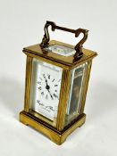 A Brights of Bristol miniature brass four glass clock with enamelled dial and arabic numerals,