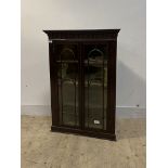 A George III mahogany wall hanging corner cabinet, with dentil cornice over arcaded frieze, two