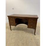 An Edwardian walnut knee hole desk, fitted with three drawers, raised on turned supports with