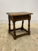 An 18th century style oak Joint stool, with floral carved frieze, turned and block supports,