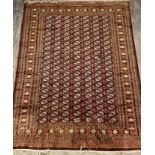 An Afghan bokhara hand knotted wool rug, the brown field with gul motif and bordered 317cm x 224cm