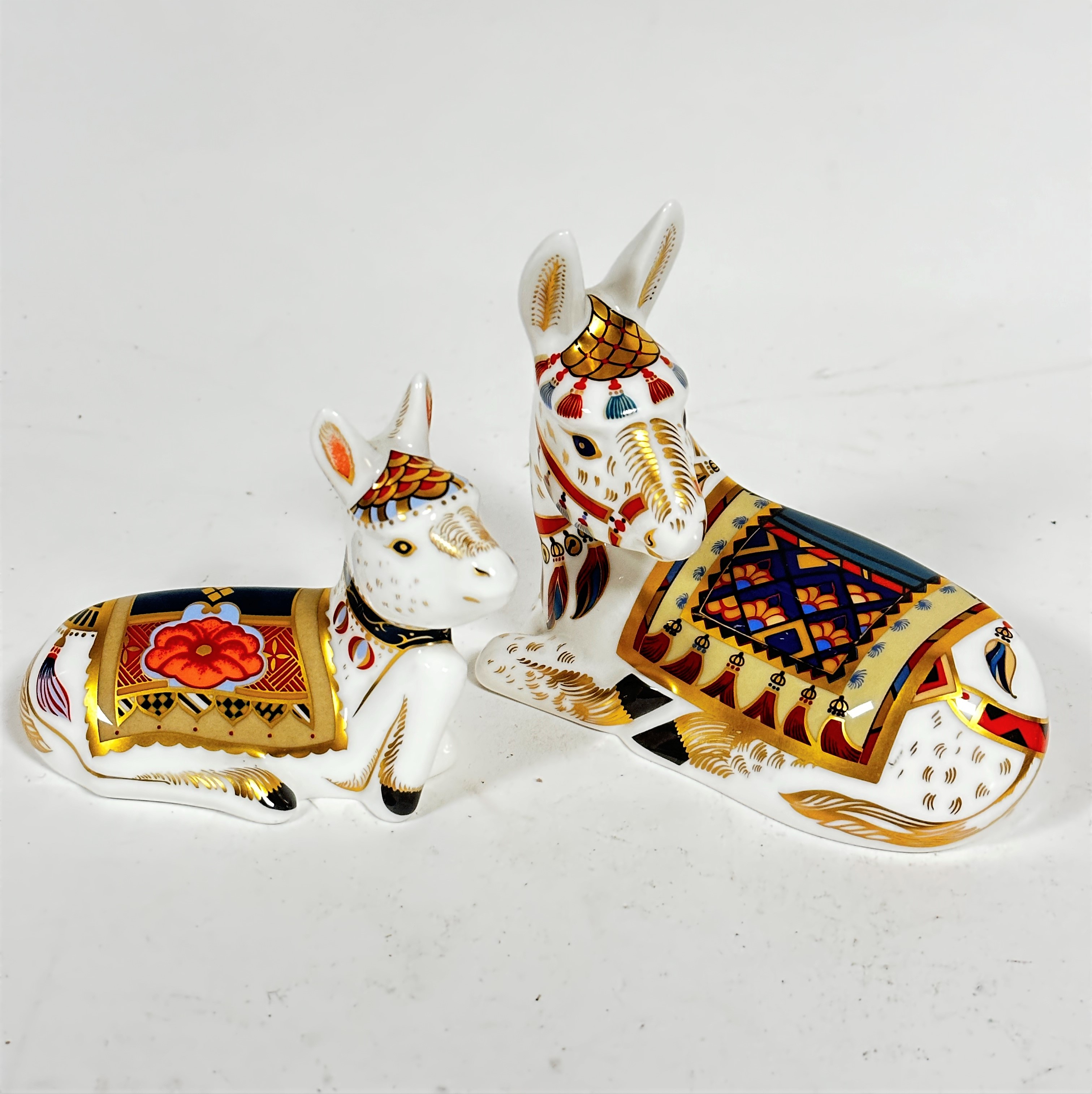 A Royal Crown Derby seated donkey and her foal, decorated with Pattern 21, (11.5cm x 13cm and foal