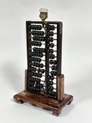 A stained Chinese upright abacus framed table lamp, the abacus of earlier origin with metal straps