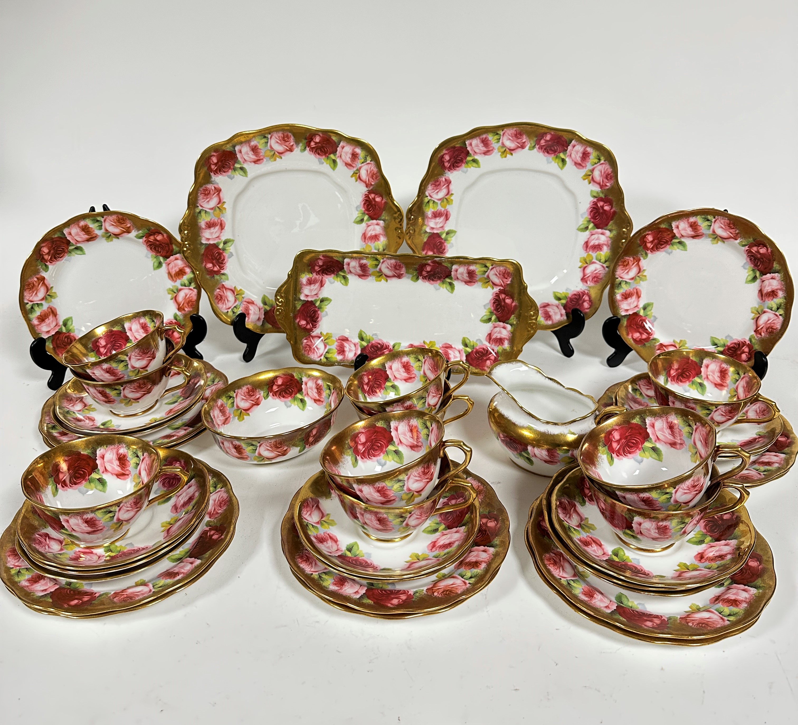 A Royal Albert pink rose and gilt bordered teaset of thirty nine pieces, including two cake