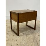 A mid century teak sewing table, the lid lifting to reveal a quantity of sewing threads, ribbon,