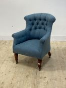 A late Victorian tub chair, upholstered in buttoned blue wool, raised on turned front supports