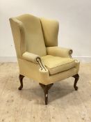 A large George II style wingback chair, upholstered in cream herringbone linen fabric, raised on