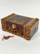 A Chinese camphor wood rectangular jewellery box with leaf carved, pagoda and figures to front, with