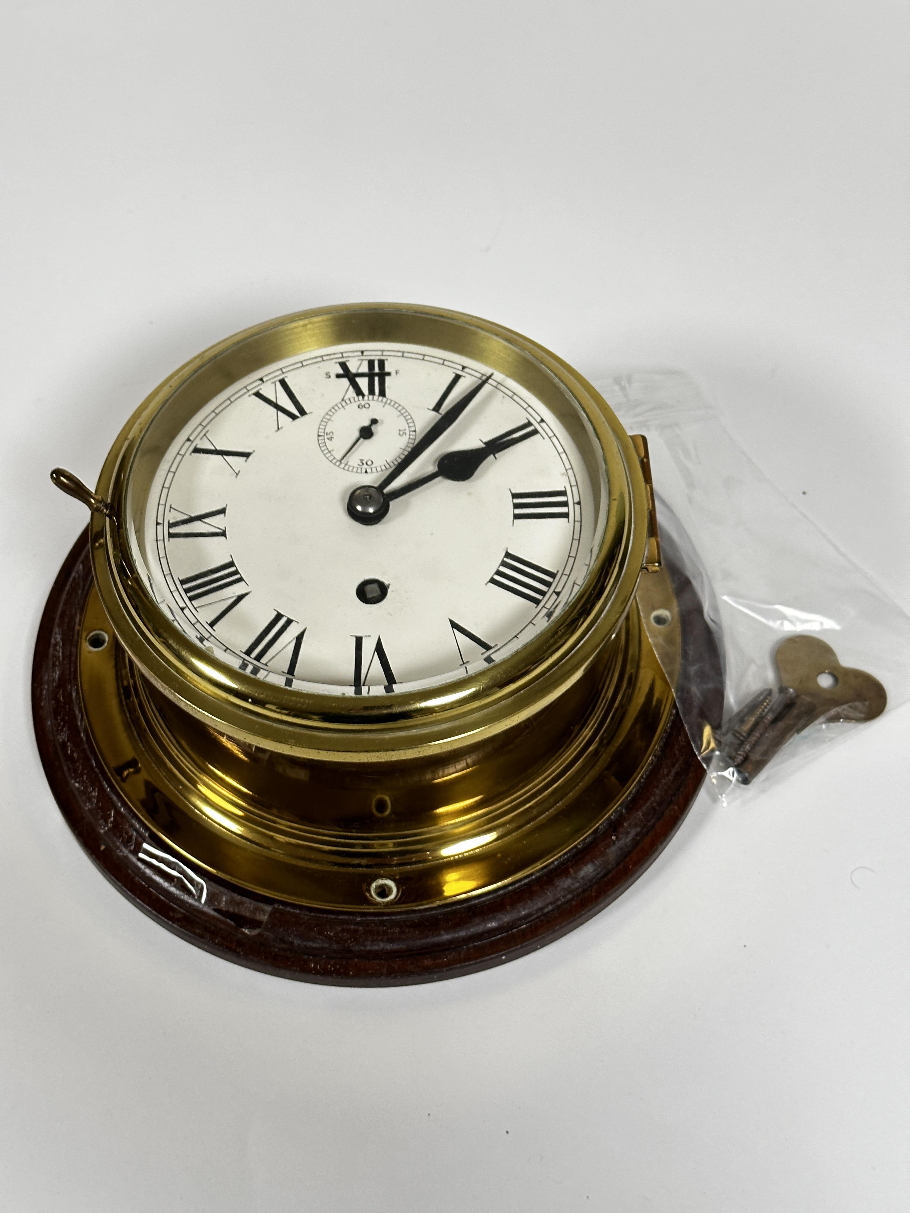An Edwardian style brass ships wall clock with enamel dial and subsidiaries dial, complete with