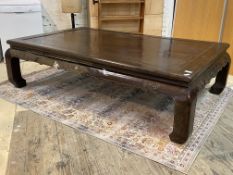 A large Chinese style rosewood low table, early 20th century, the panelled top over scrolled