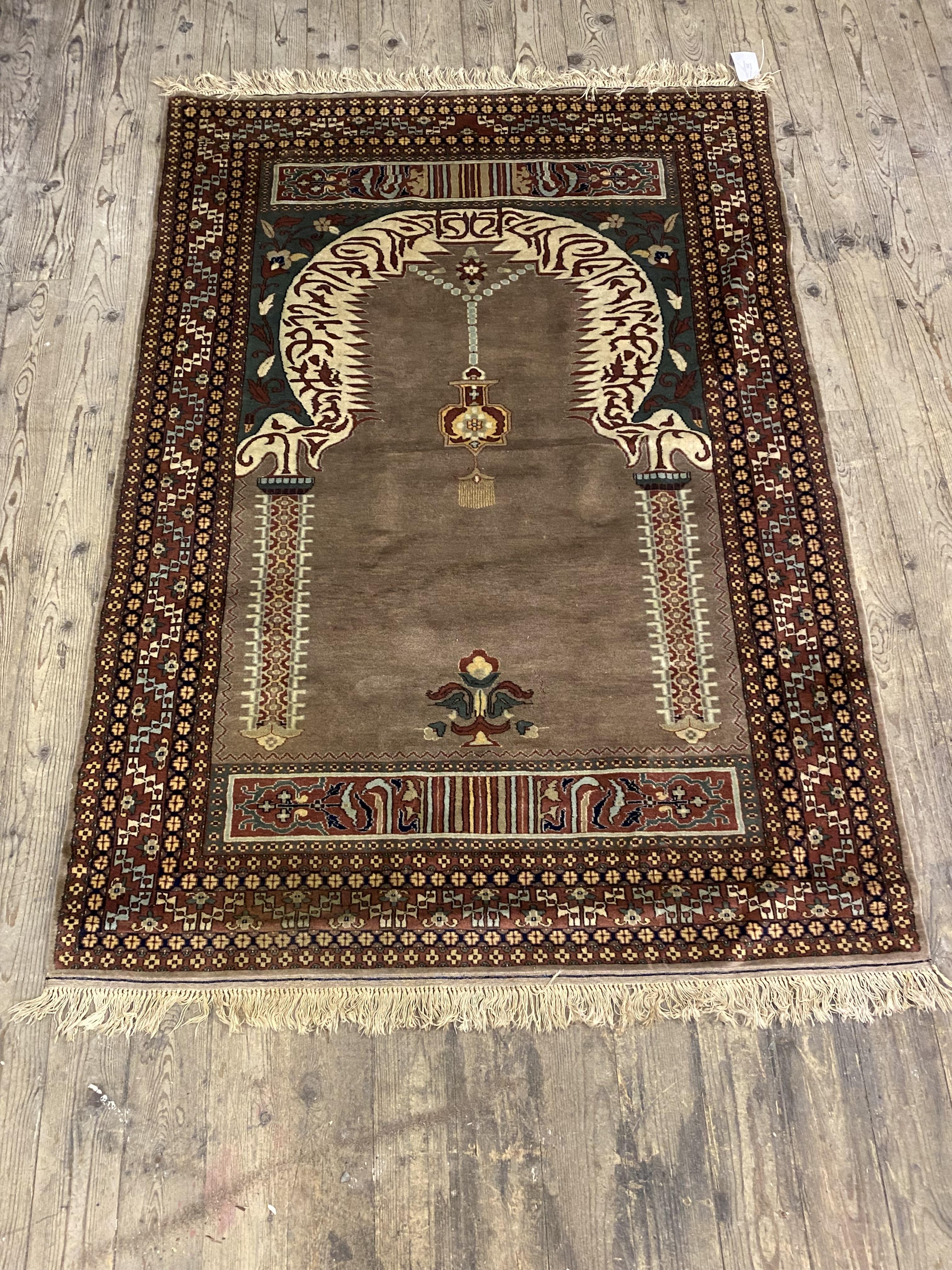 A Persian prayer rug, hand knotted, the field with mihrab within a multi line border 128cm x 92cm