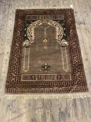 A Persian prayer rug, hand knotted, the field with mihrab within a multi line border 128cm x 92cm