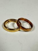 An 18ct gold wedding band (L/M) (5.58g) and a yellow metal wedding band (cut) (M/N) (0.5g) (2)