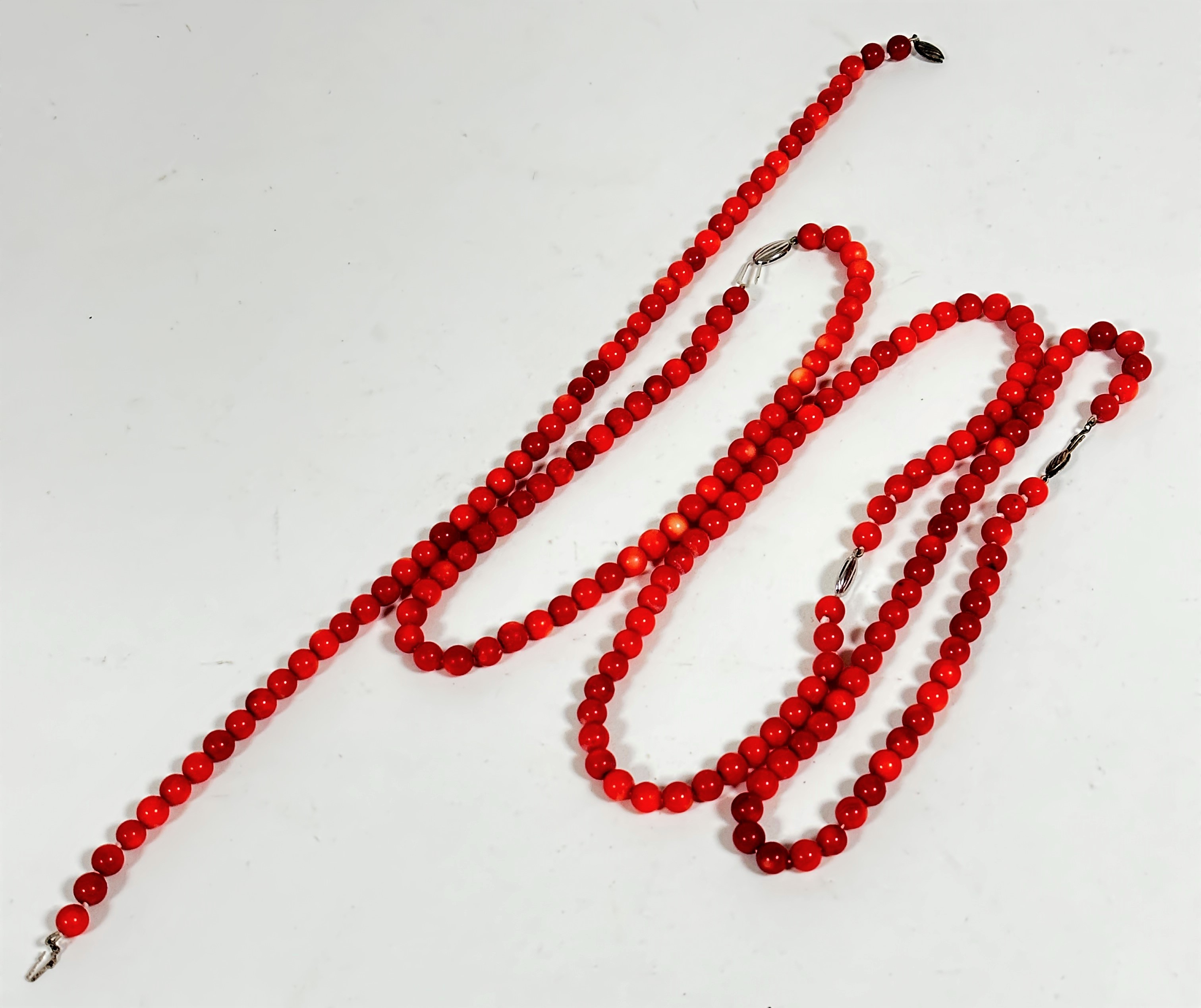 A collection of four red dyed coral bead necklaces, (L 42cm, beads d 7cm approximately)