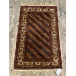 A Persian style rug, the red ground with geometric design within an ivory border 79cm x 143cm