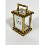 A Postilion quartz four glass clock with handle to top and enamel dial with roman numerals (h.14cm x